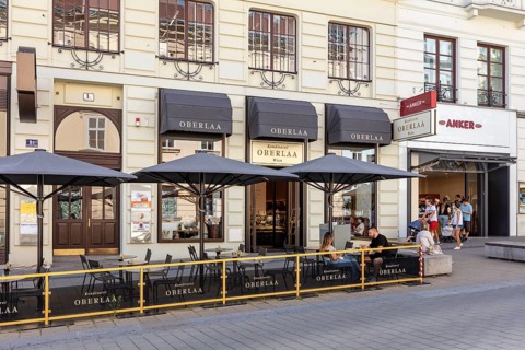 Inviting street café with classic façade and shady parasols, Vienna
