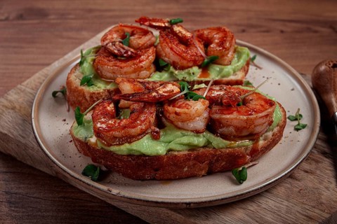 Sandwiches with avocado and caramelized shrimp, micro-greens, breakfast, on a plate, top view,