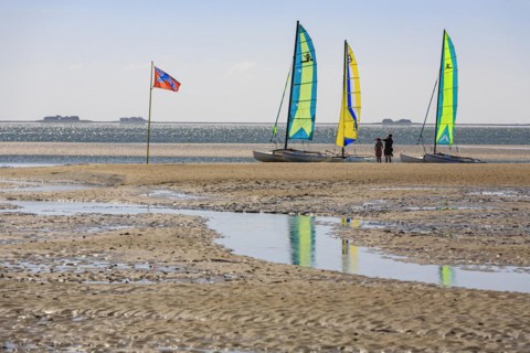 Small sailing boats on the beach, catamaran, behind Halligen, backlight, sunny, summer, North Sea