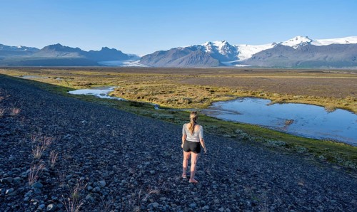 Tourist in front of Icelandic landscape, view of glacier tongues Skaftafellsjökull and