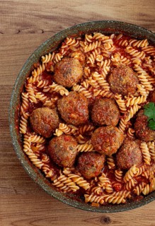 Minced meat meatballs, in tomato sauce, with fusilli pasta, in a cast-iron pan, homemade, no people