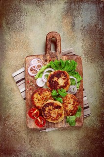 Fried chicken cutlets, minced chicken, with vegetables, on a cutting board, with vegetable salad,
