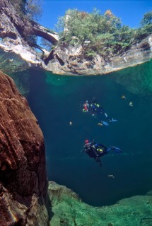 View from underwater through the water surface of the river Orrido di Sant' Anna on top foreground