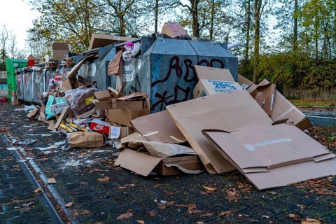 Overfilled waste paper containers, despite the overcrowding, people have put their waste paper next
