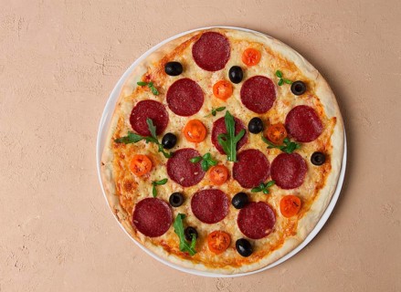Pepperoni pizza, with olives and cherry, homemade, on a beige background, top view, no people