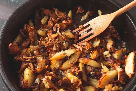 Fried chanterelles with mushrooms, in a clay pan, close-up, top view, selective focus