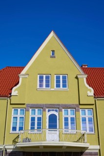 House gable with red tiled roof and white windows against a clear blue sky, Molde, Romsdal, Norway,