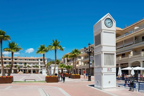 Modern square with clock tower and palm trees under a blue sky, Plaza de España, Nerja, Province of