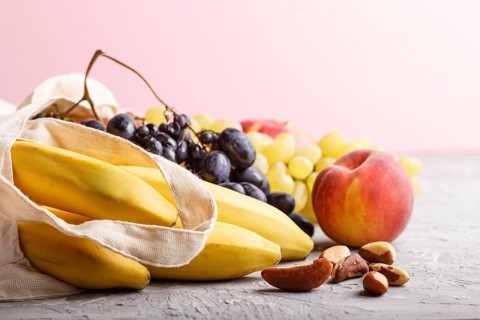 Fruits in reusable cotton textile white bag. Zero waste shopping, storage and recycling concept,