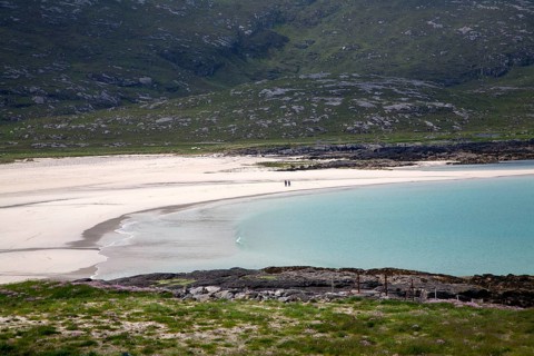 A couple walking in the distance on sandy beach in Halaman bay, Barra, Outer Hebrides, Scotland, UK