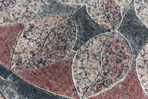 Granite leaf-like mosaic maroon-black element in the park