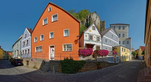 Colourful house front on Vils Gasse with a clear rock face in the background, Kallmünz, Upper