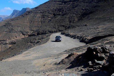 Car driving on unsurfaced road, Atlantic Ocean coast, Jandia peninsula, Fuerteventura, Canary