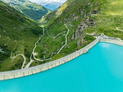 Dam of the Moiry lake, Lac de Moiry, turquoise glacial water, parking lot and restaurant at the