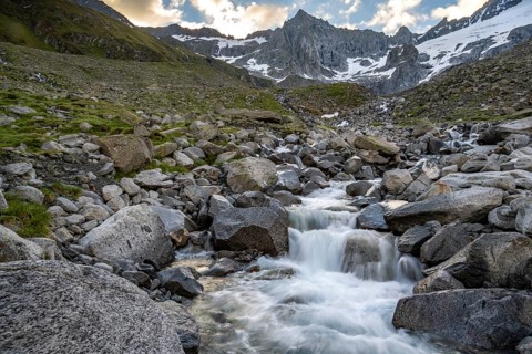 Mountain stream Furtschaglbach at sunrise, long exposure, rocky mountains behind, summit
