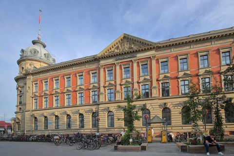 Historic building of the Sparkasse, former main post office, people, bicycles, car park, market