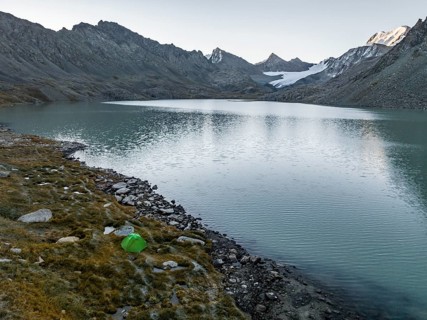 Wild camping, camping with tent in the mountains with glacier, mountain pass and mountain lake
