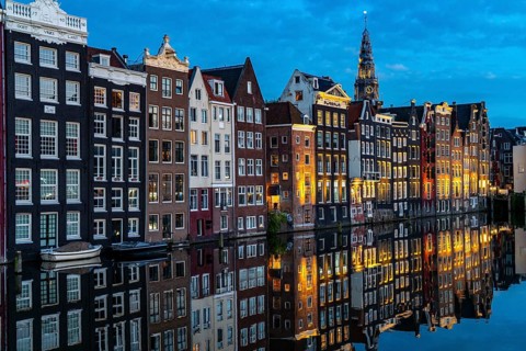 Canal houses on the Damrak, in the centre of the old town of Amsterdam, harbour, starting point of