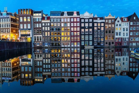 Canal houses on the Damrak, in the centre of the old town of Amsterdam, harbour, starting point of