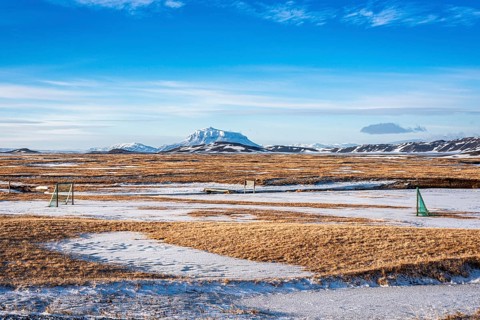 View over snow-covered football playground towards Mt. Herdubreid, winter, farm Mödrudalur, located