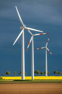 Wind turbines on a rape field, dark rain clouds, in the Rhenish lignite mining area, near