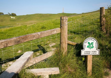 National Trust sign Cherhill Down and Oldbury Castle with Lansdowne monument, Cherhill, Wiltshire,