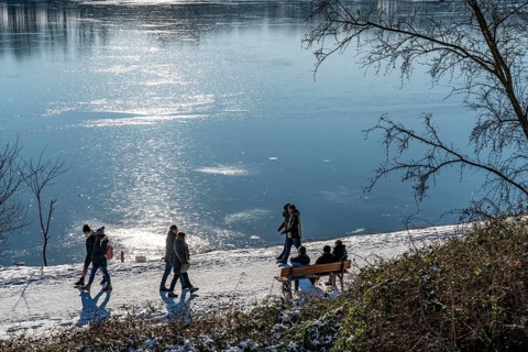 Winter in the Ruhr area, Lake Baldeney, snow-covered, partly frozen lake, walkers on the lakeside