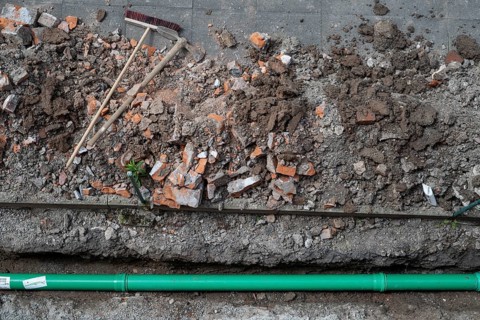 Newly laid green sewage pipe, trench, excavation, broom and pickaxe, Stuttgart, Baden-Württemberg