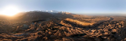 Panorama, White glaciated and snow-covered mountain peak Pik Lenin at sunrise, hilly landscape with