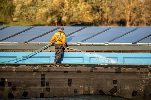 Sailor cleaning a cargo ship on the Rhine near Xanten, Lower Rhine, North Rhine-Westphalia,