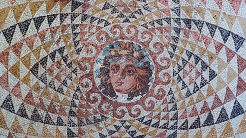 Head of Dionysus with fruit and ivy in his hair, finely worked antique mosaic with a centred