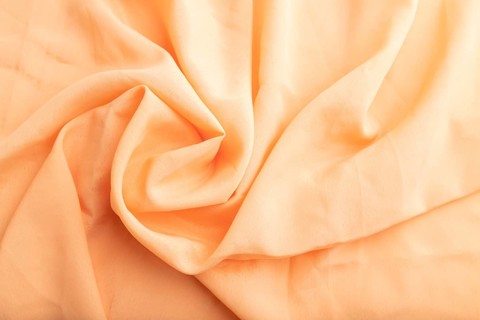 Fragment of orange linen tissue. Top view, flat lay, natural textile background and texture. wave
