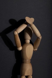 Wooden mannequin stands with raised hands on gray background. protest, attention concept. copy