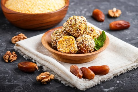 Energy ball cakes with dried apricots, sesame, cornflakes, linen, walnuts and dates with green mint