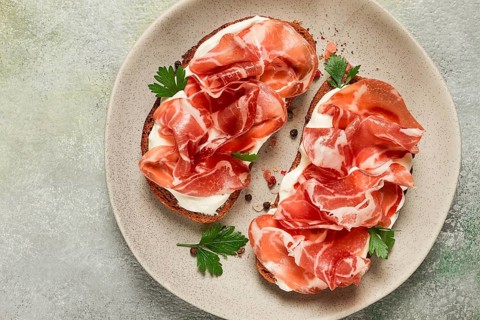 Sandwich with cream cheese and prosciutto, on black grain bread, breakfast, homemade