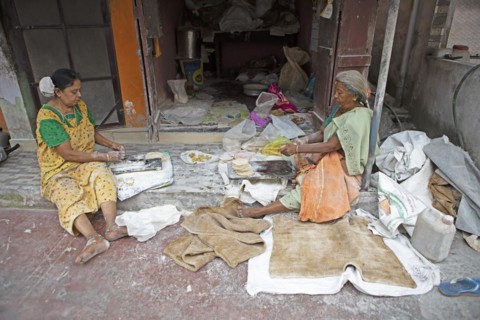 Indian woman making pappadam or Indian bread on the footpath, Kochi, Kerala, India, Asia