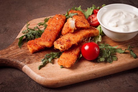 Fried fish nuggets, with white sauce, arugula and cherry, no people
