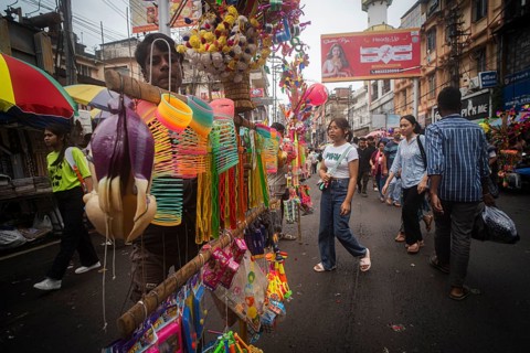 Vendor sells toys and other children items at a street market ahead of Durga Puja festival on