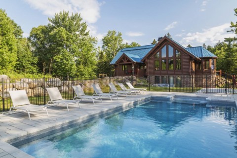 In-ground salt water swimming pool and brown stained milled Eastern white pine timber and flat log