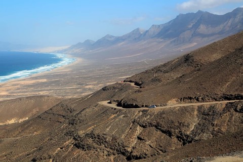 Car driving on unsurfaced road, Atlantic Ocean coast, Jandia peninsula, Fuerteventura, Canary