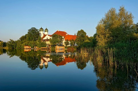 Romanesque Benedictine Abbey Seeon Monastery, monastery church St. Lambert with reflection in the