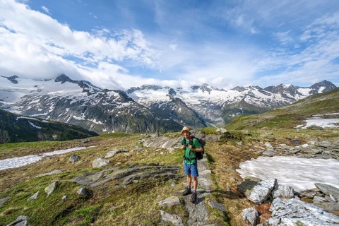 Mountaineer on hiking trail in picturesque mountain landscape, mountain peak with snow and glacier