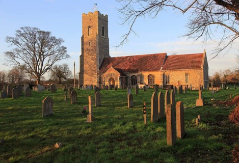 Late afternoon winter golden light falls on Saint John the Baptist church, Snape, Suffolk, England,