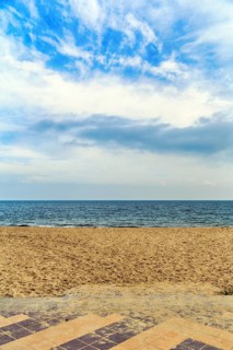 View from the empty sandy beach to the sea and cloudy sky, sunny autumn weather, full format, Wyk