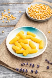 Jelly corn candies on gray wooden background and linen textile. close up, side view