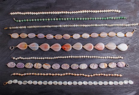 Set of semiprecious stone beads on a black background, top view