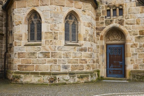 Facade of St Laurentius Church with stained glass windows and a side door in Warendorf, Warendorf