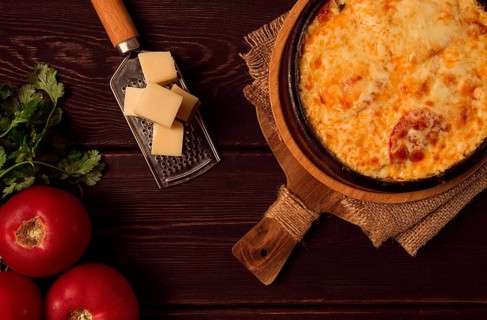 Baked tomatoes with Suluguni cheese, Ketsi in a clay pan, Georgian dish, homemade, top view, on a