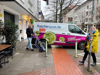 Delivery vehicle of the delivery service Flaschenpost.de parks on a pavement during delivery,
