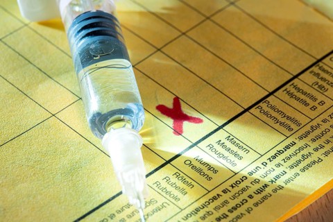 Symbolic photo measles vaccination, vaccination certificate, syringe with measles vaccine